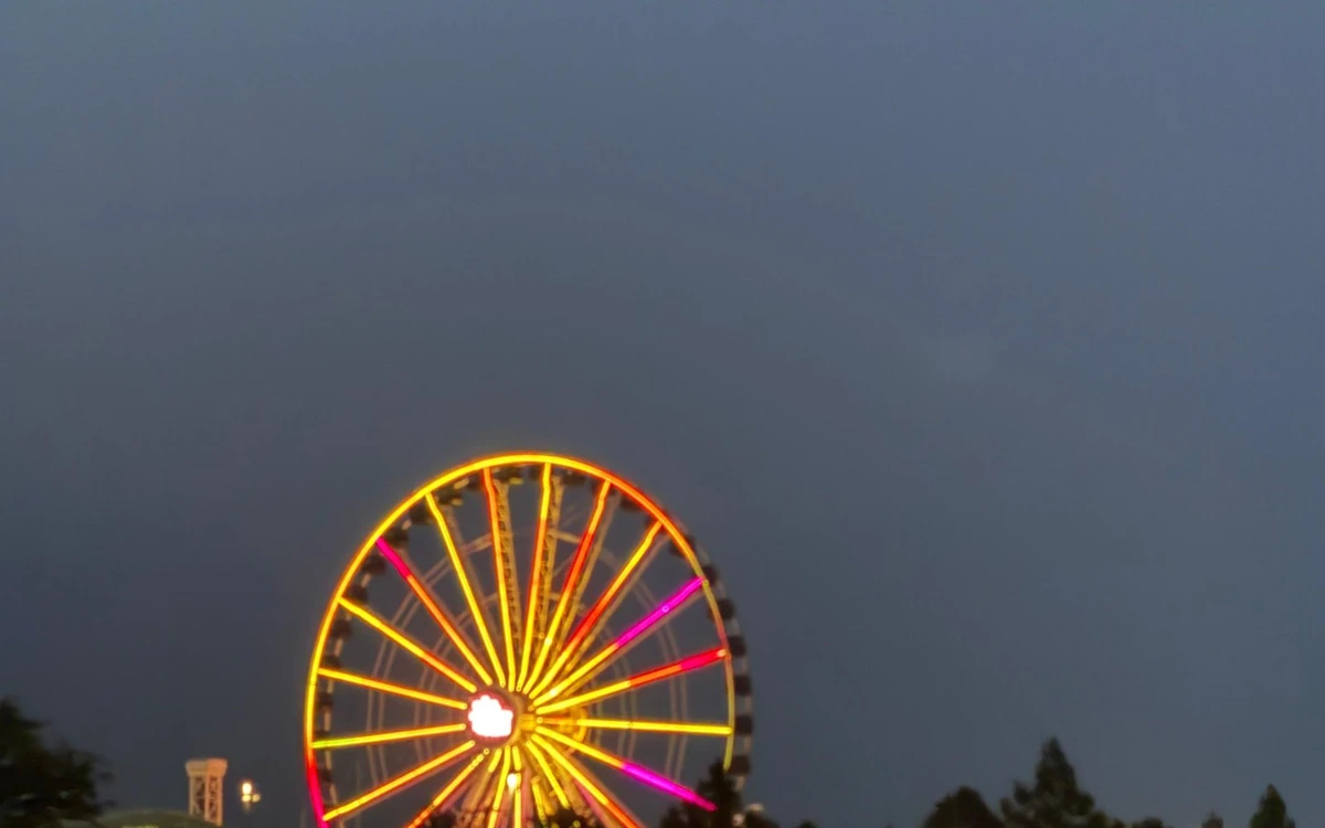 A lit Ferris wheel against a dark blue evening sky