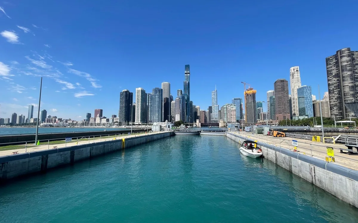 A boat in a lock, with the downtown skyline behind it