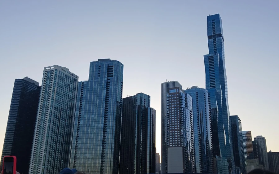 Glass towers rising straight up from the riverbank, seen from below