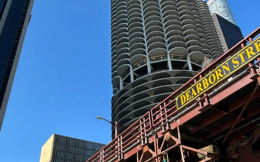 A round high-rise tower beside the red Dearborn Street bridge