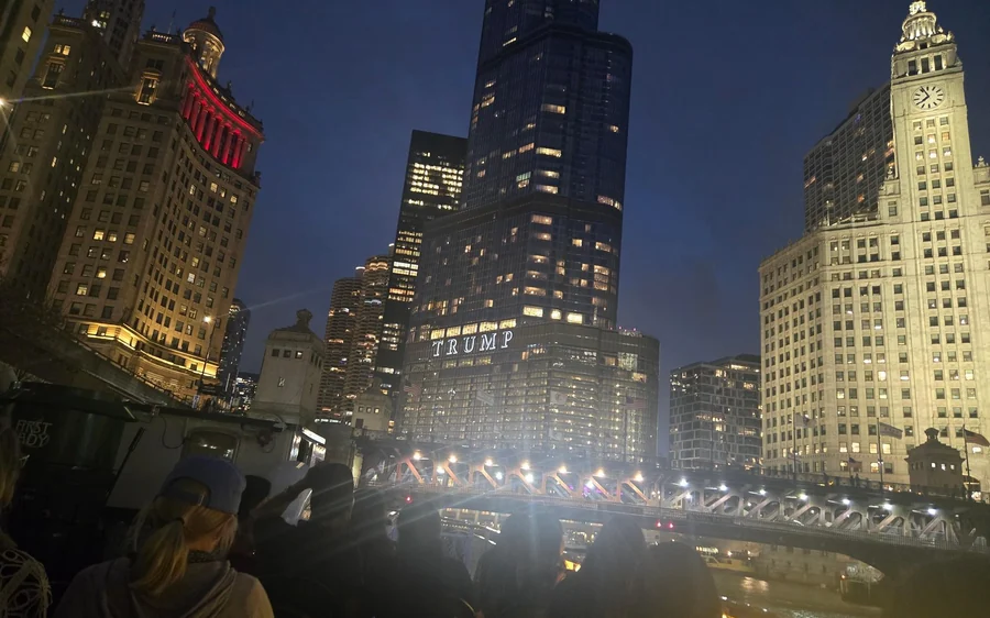 Lit towers and a bright bridge over the river at night